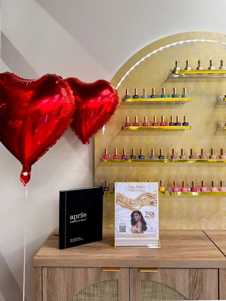 Nail salon display with red heart balloons and nail polish color swatches
